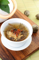 Tied green tea blossoms in a tea cup
