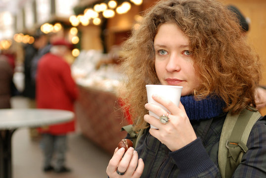 woman with mulled wine at christmass fair