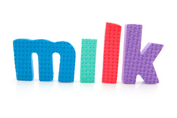 Word milk in foam letters over white background