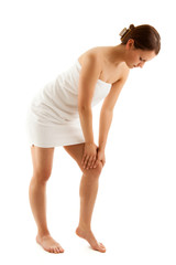 Obraz premium Woman massaging pain knee on white background