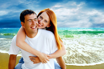 Young love couple smiling under tropical beach