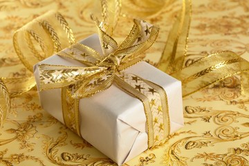 Beautiful gift box on the gold background