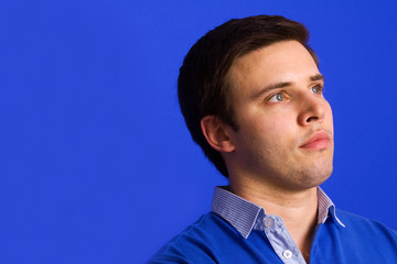 Obraz premium Pensive young casual man, on a blue background