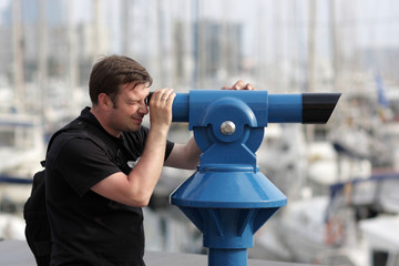 Fototapeta na wymiar Man looks through telescope