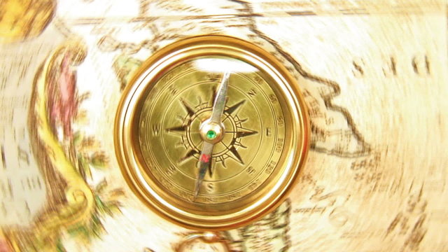 Old brass compass over antique map