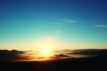 Sunrise over misty mountains