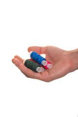 hand holds the spool of thread for sewing isolated over white