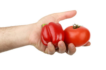 The man's hand holds sweet  red tomato and pepper