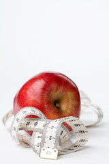 Tape measure and apple. Focus on tape measure