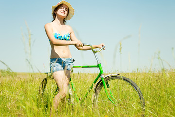 girl with  bicycle in grass