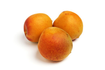 three apricots on white background