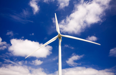 Windmill against a blue sky and clouds, alternative energy sourc