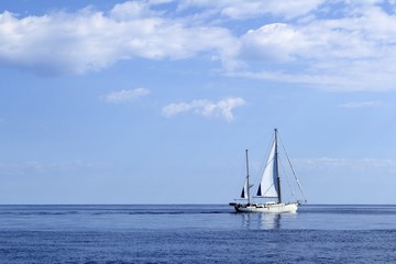 Fototapeta premium Sailboat sailing on blue sea horizon ocean