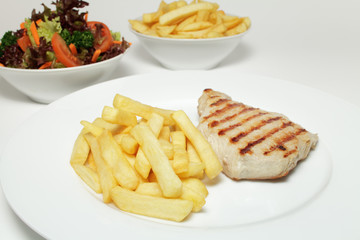 Schweinesteak vom Grill mit Pommes frites und Salat