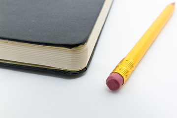 Bleistift mit Radiergummi neben Notizbuch