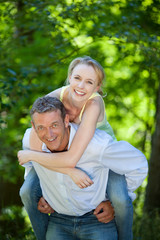 Fototapeta premium mann trägt frau im huckepack