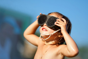 Naklejka premium Little girl looks at sun
