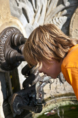 Obraz na płótnie Canvas boy enjoys public trinking water