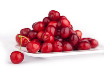 Kirschen auf einem weißem Teller isoliert mit Schatten