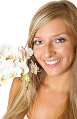 Young blond tan caucasian woman with orchid flowers isolated