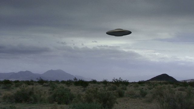 UFO 10: A flying saucer hovers over a windy desert.
