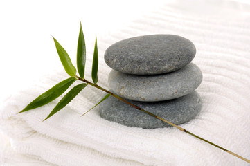 Fototapeta na wymiar Zen stones with bamboo leaf on towel