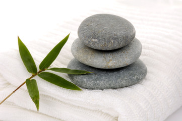 Fototapeta na wymiar Zen stones with bamboo leaf on towel