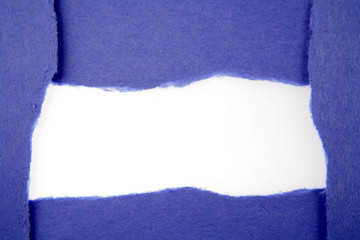 Hole ripped in blue paper on white background