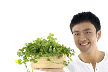 Close up young man holding a plant