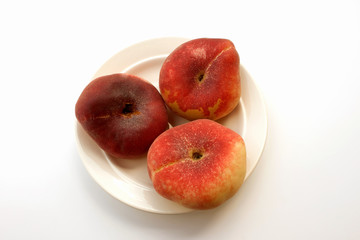 Donut peaches on a white saucer (close up)