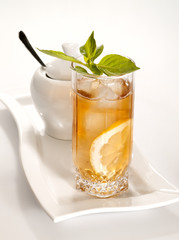 glass of cold green tea with ice, mint  and lemon on the plate