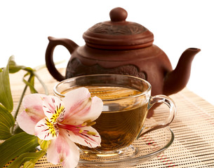 Cup of green tea on the table with orchid flower