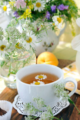 Field flowers and chamomile tea (background)