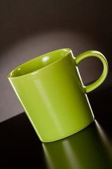 Green cup on a grey gradient background