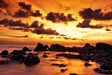 Fototapeta na wymiar Tropical sunset on the stones beach. Thailand