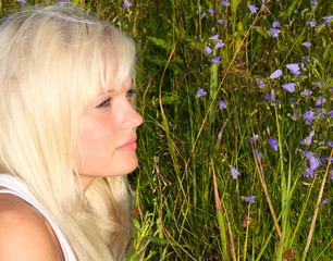 Blond haired, blue eyed model lie in grass