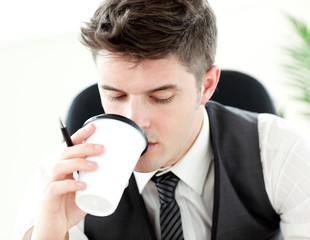 Young businessman drinking coffee in the office