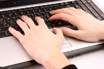 Closeup of male fingers typing a document on the black laptop