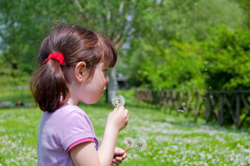 Girl blowing a dandalion