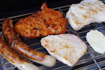 Turkey, sausages and steak on electric bbq grill