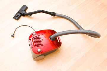 Vacuum cleaner on the wooden floor