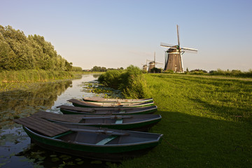 Three historic windmills with rowing boats