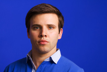portrait of young casual man, on a blue background