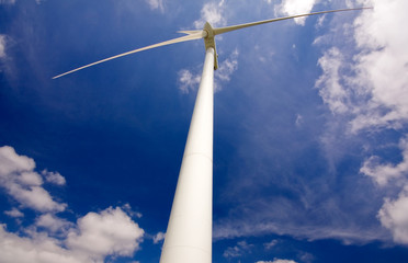 Windmill against a blue sky and clouds, alternative energy sourc