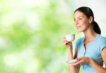 Young happy smiling woman drinking coffee, outdoors