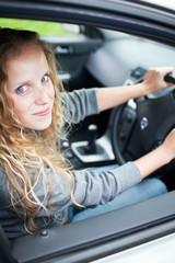 Obraz na płótnie Canvas Pretty young woman driving her new car