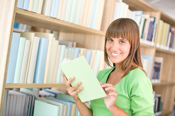 Student in library - cheerful woman choose book