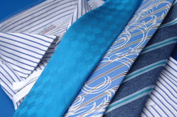 ties of different colors lie on a shirt
