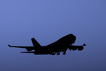 Silhouette of  jet in flight at sunset.