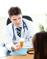 Assured male doctor giving his patient pills